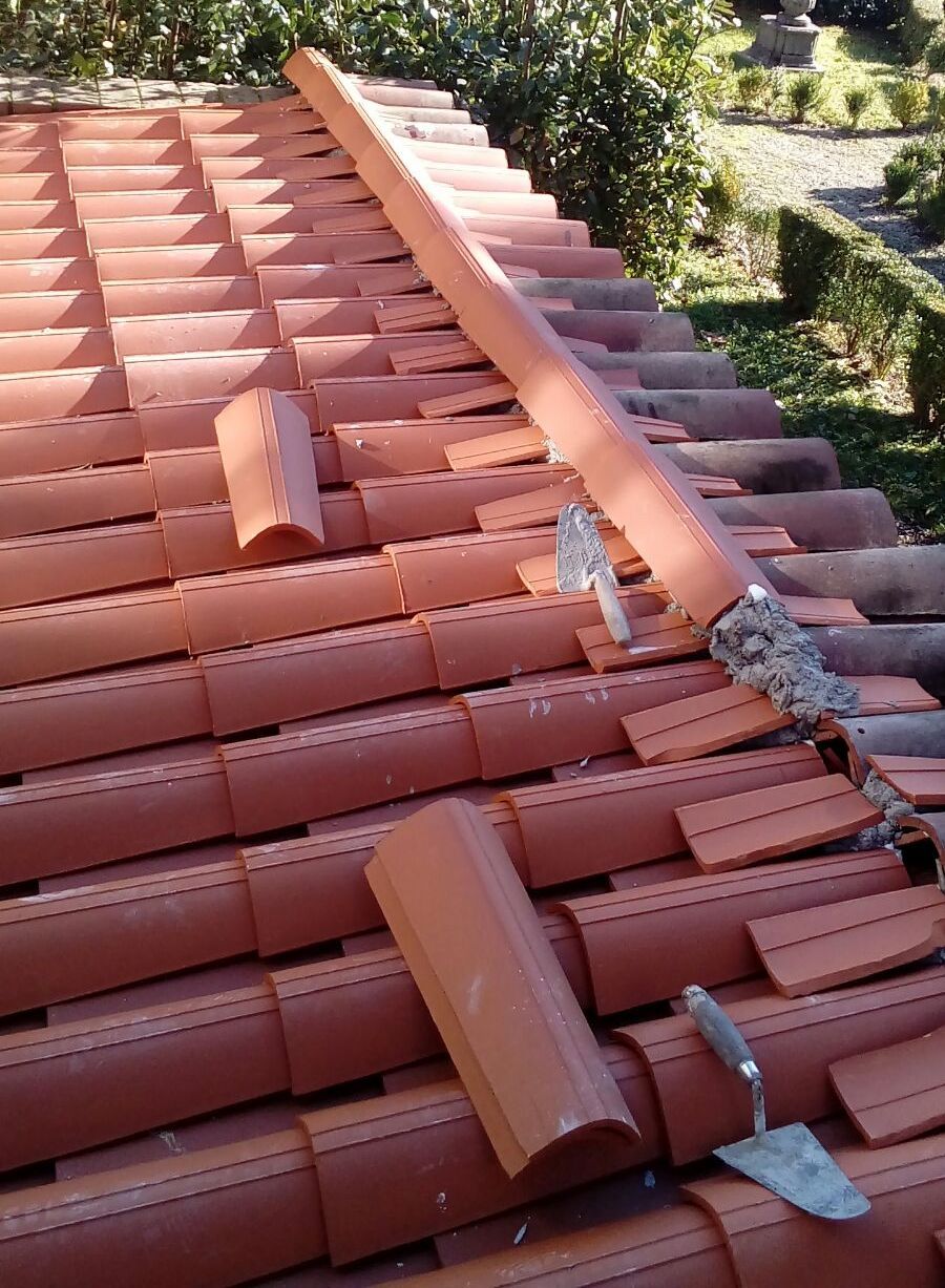 Tegole rosse, con una sezione rotta e una cazzuola, all'esterno.