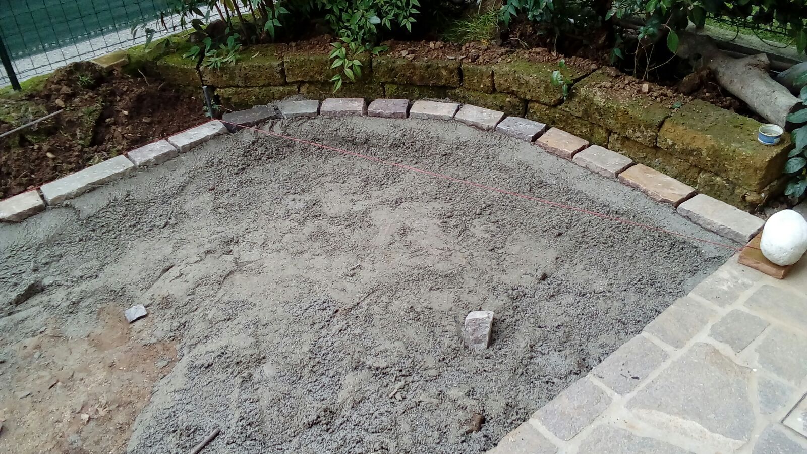 Un mucchio di ghiaia è appoggiato sopra un patio in pietra.