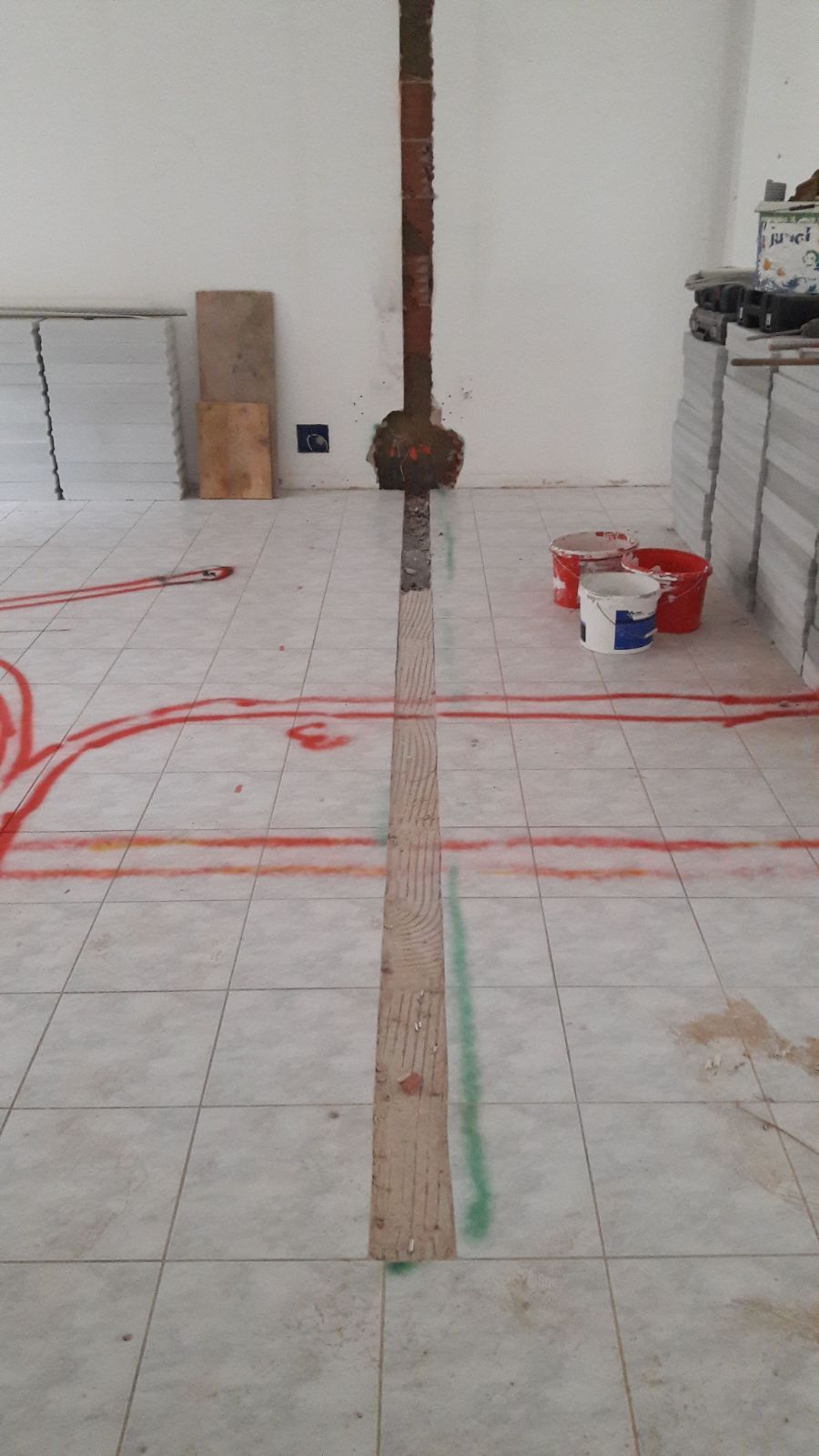 Una stanza con pavimenti piastrellati e un palo di legno al centro della stanza.
