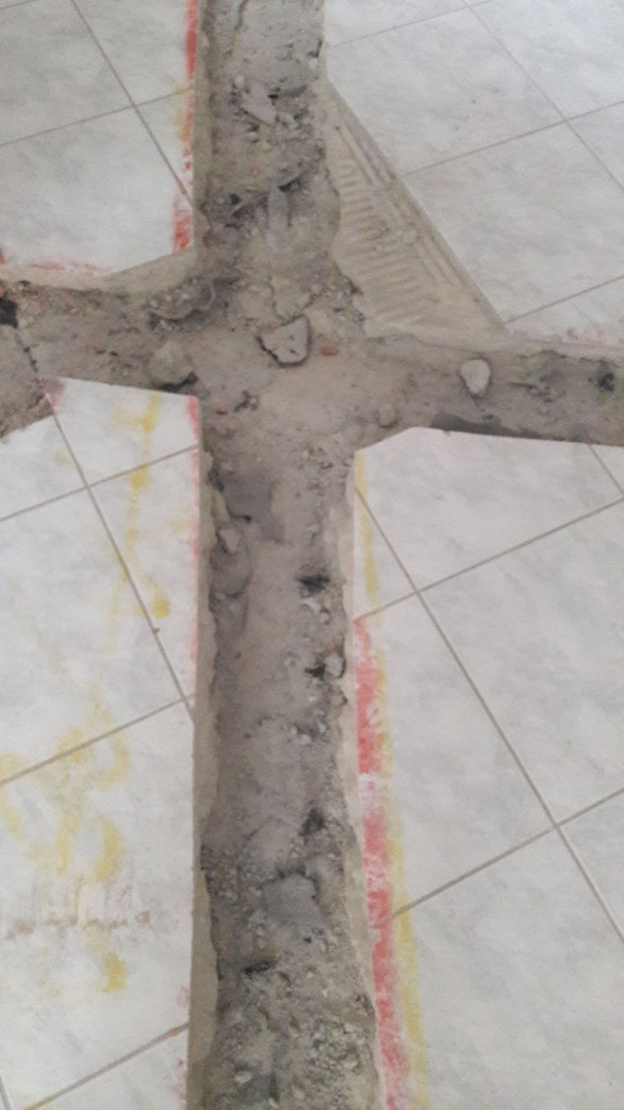 Primo piano di una croce di cemento su un pavimento piastrellato.