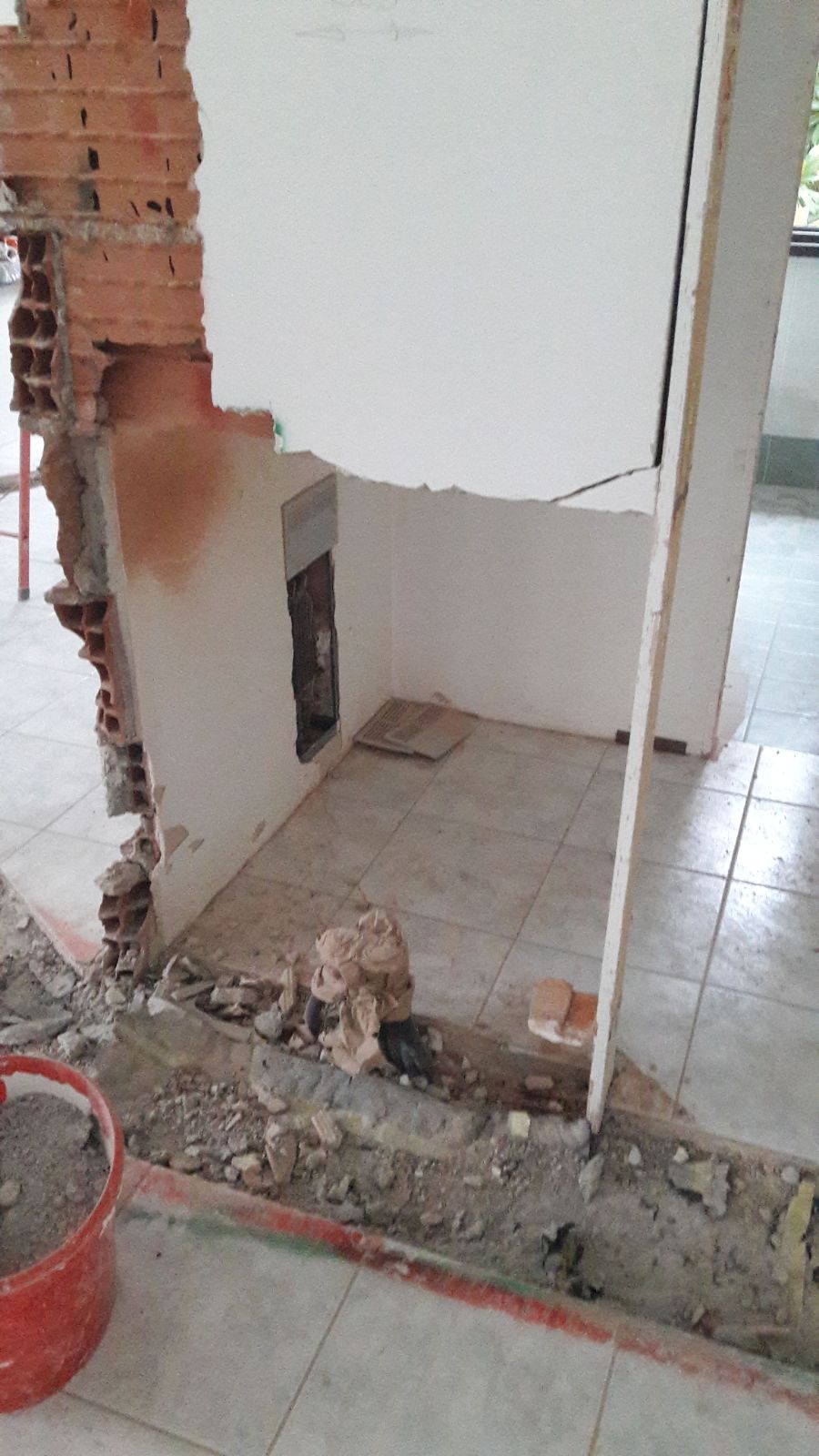 In una stanza viene abbattuto un muro di mattoni.