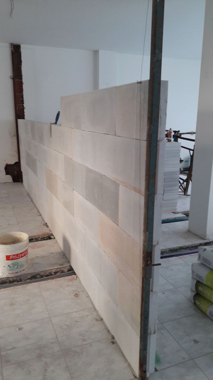 In una stanza viene costruito un grande muro.