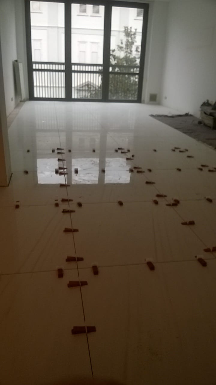 Una grande stanza vuota con un sacco di piastrelle sul pavimento