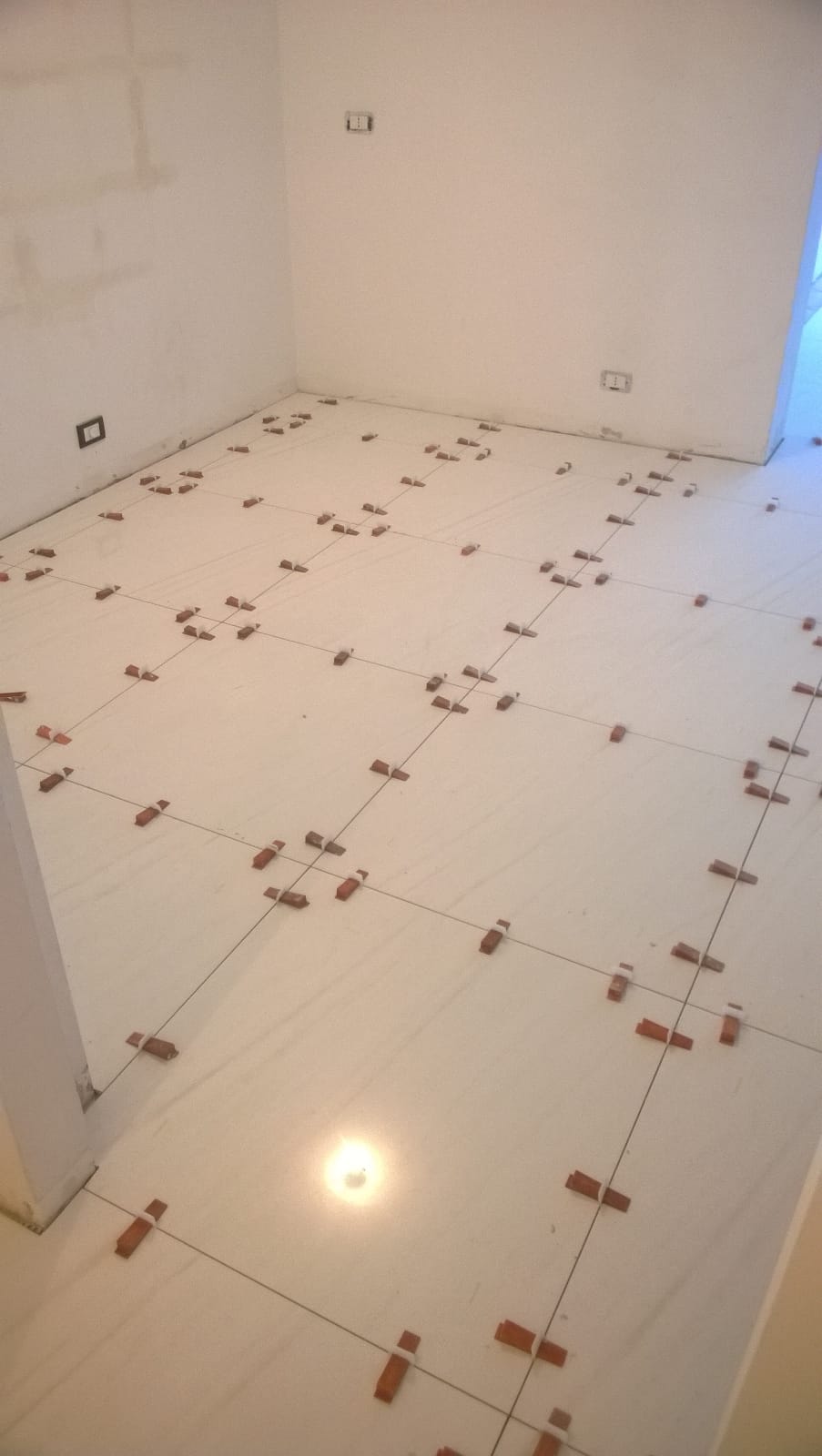 Un pavimento di piastrelle bianche con molti mattoni sopra