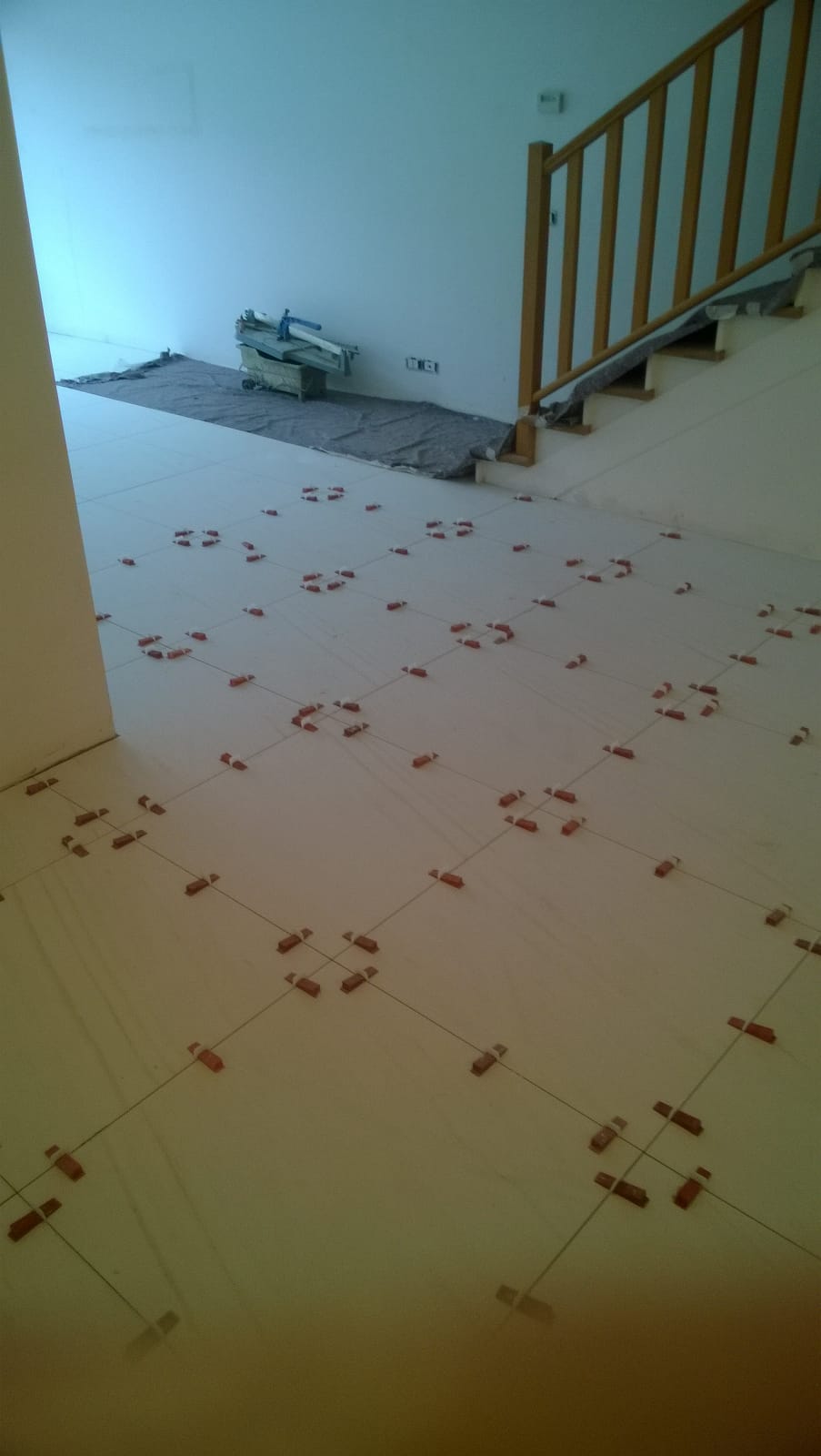 Una stanza con una scala e un sacco di piastrelle sul pavimento.