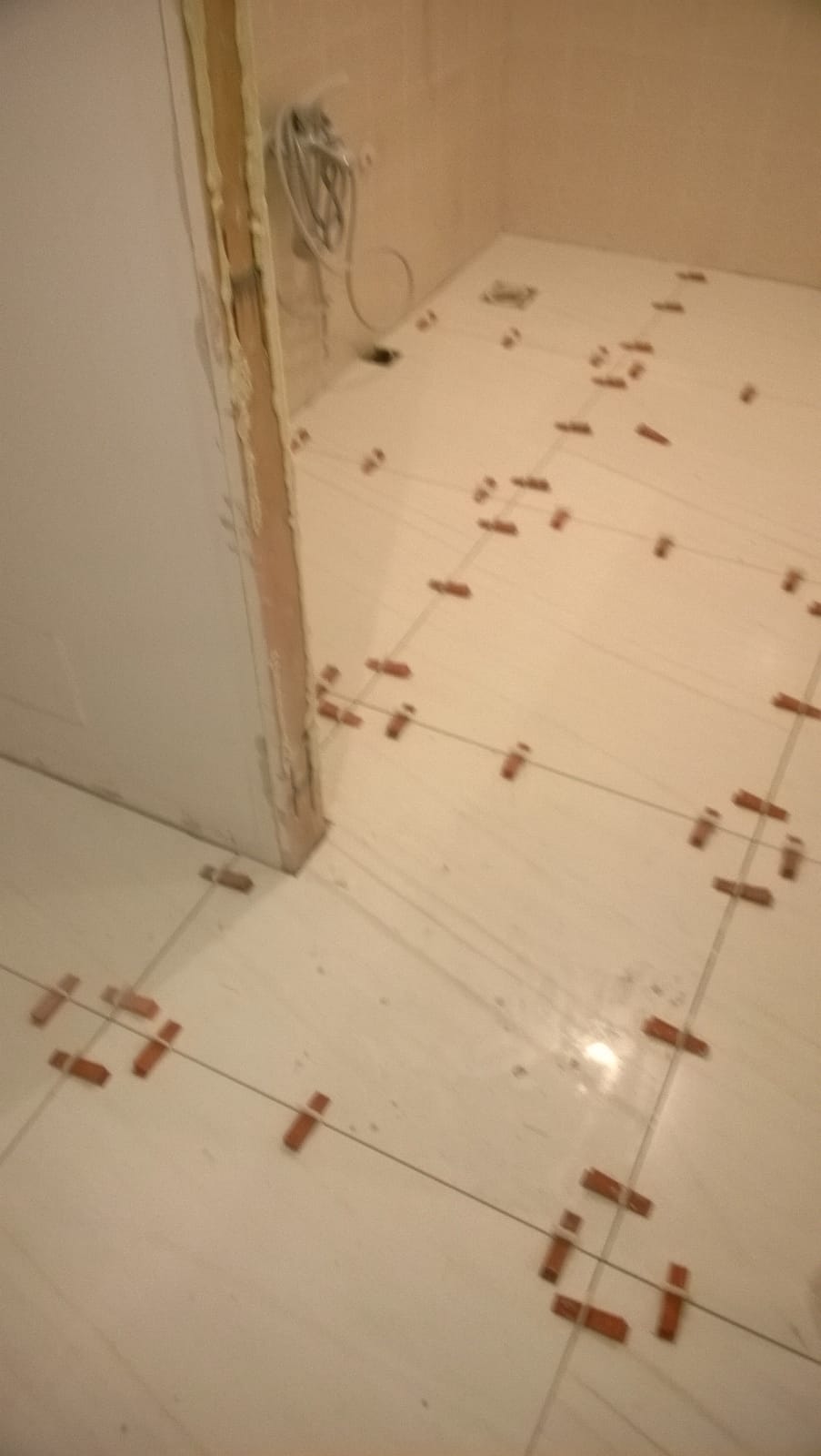 Un pavimento di piastrelle bianche con una porta sullo sfondo.