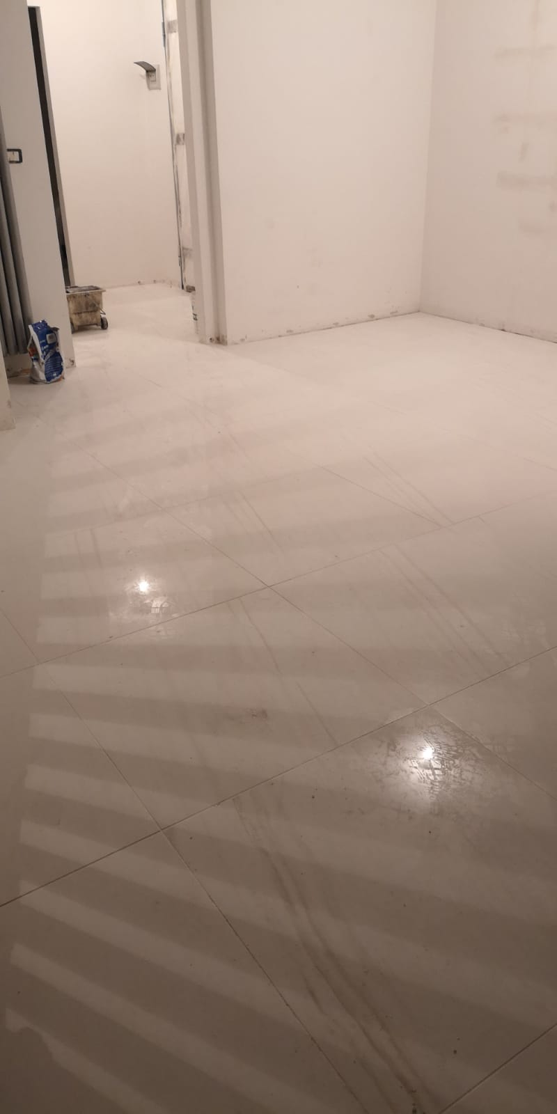 Una stanza con pavimento e pareti bianche.