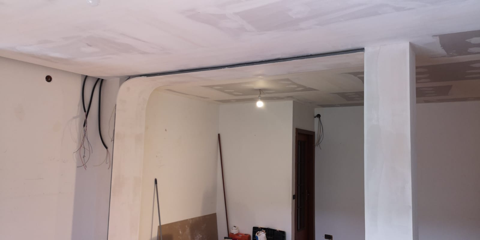 Una stanza con pareti bianche e una luce sul soffitto.