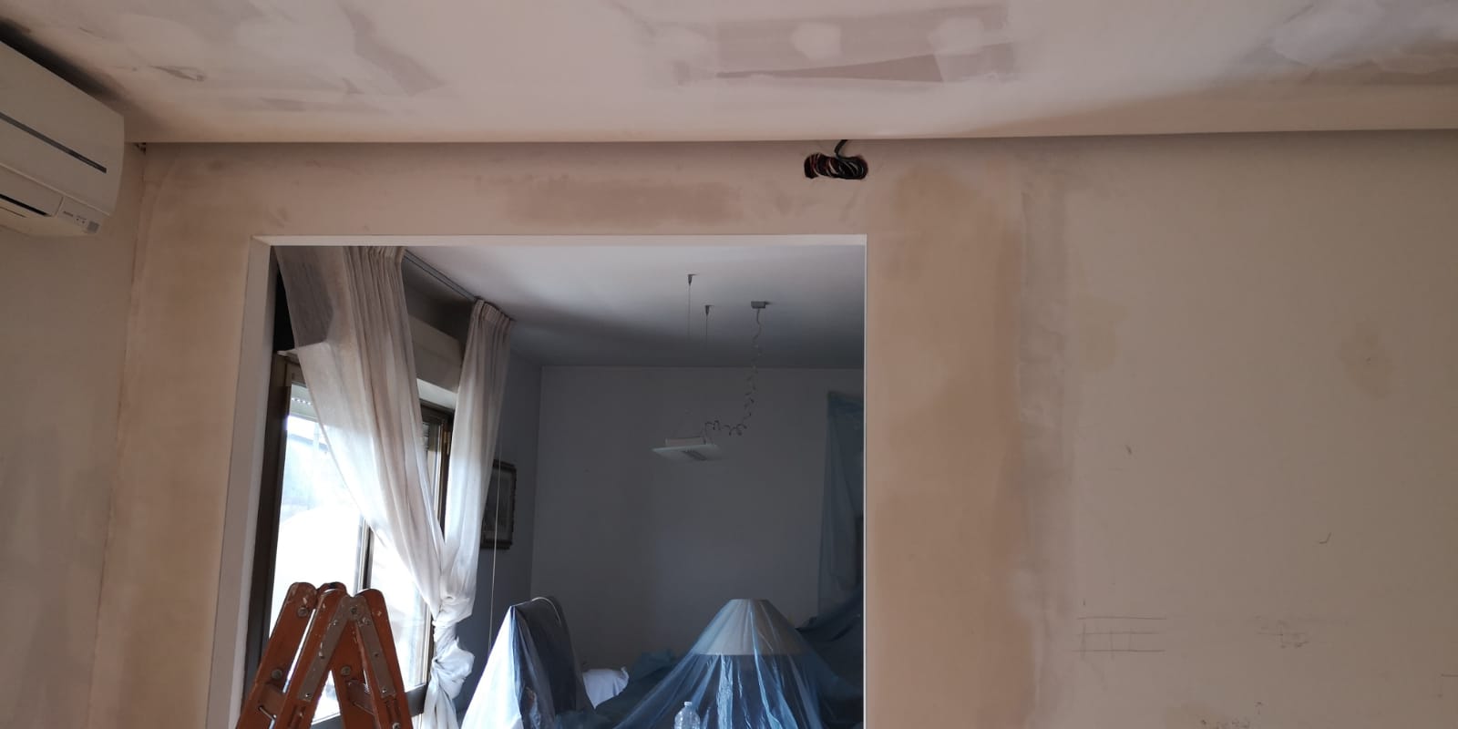 Una stanza con una finestra e una scala al suo interno.