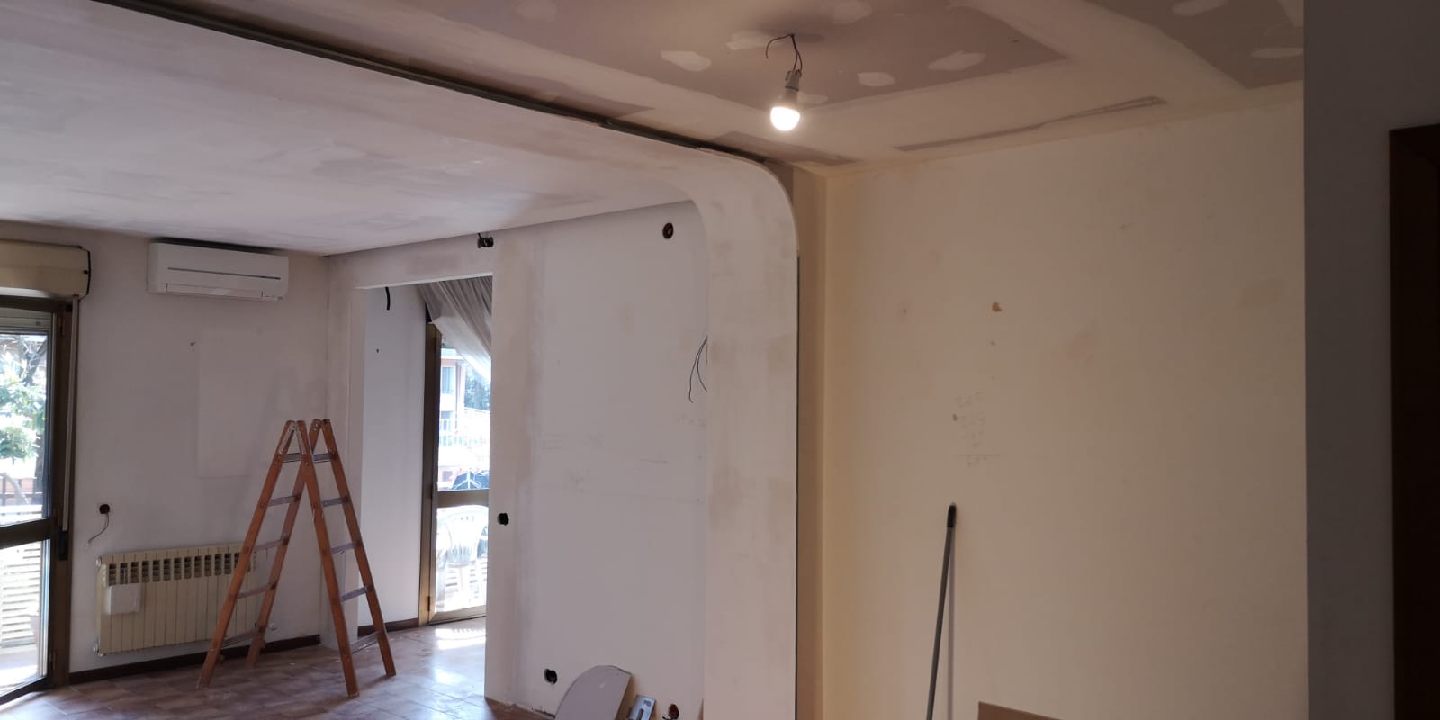 Una stanza con una scala e uno straccio dentro.