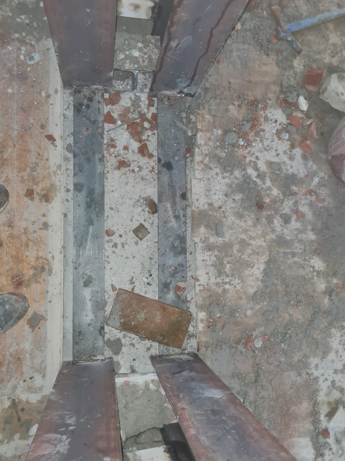 Un primo piano di una struttura metallica con mattoni a terra