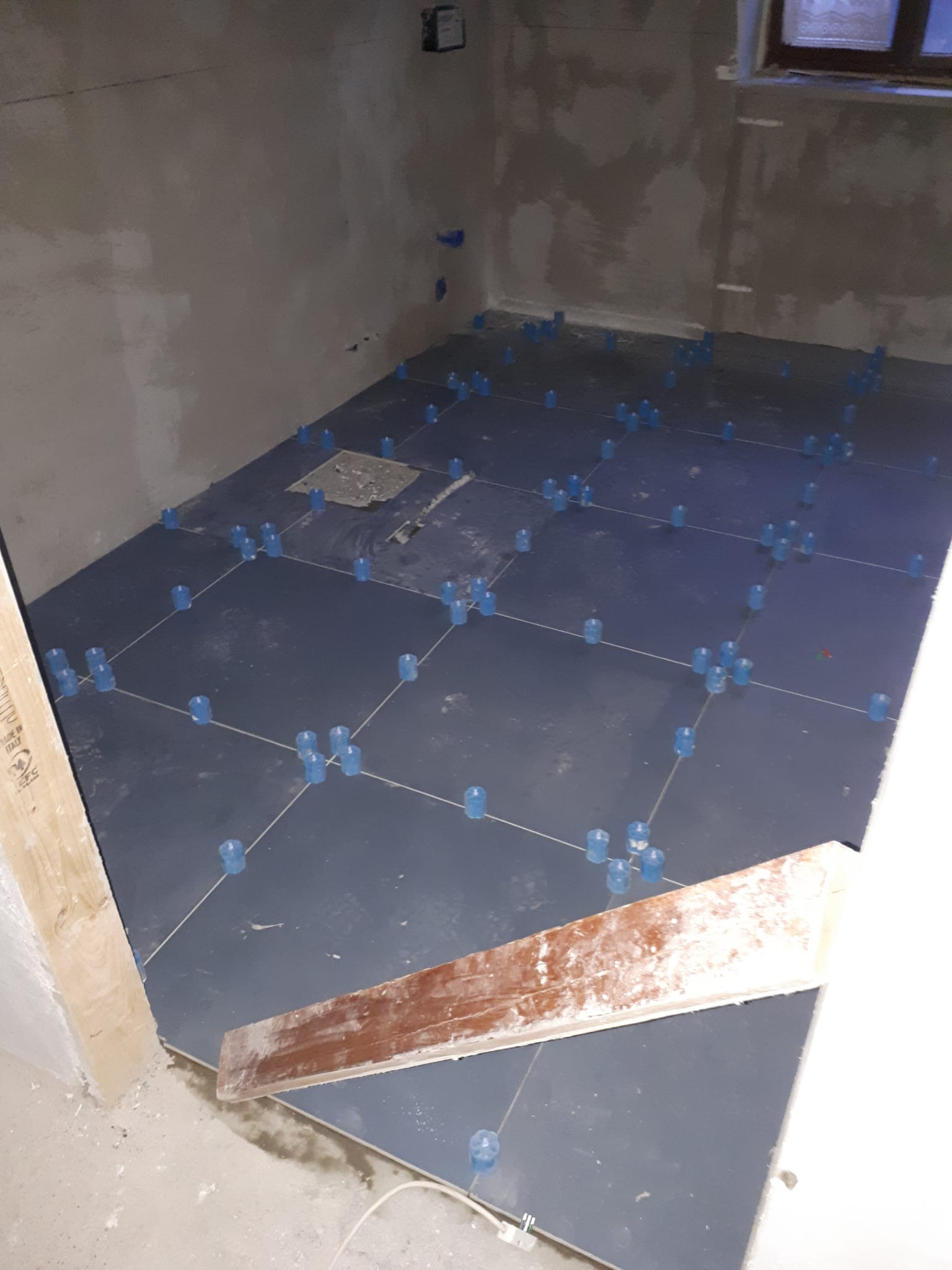 Una stanza con un sacco di piastrelle sul pavimento e una finestra.