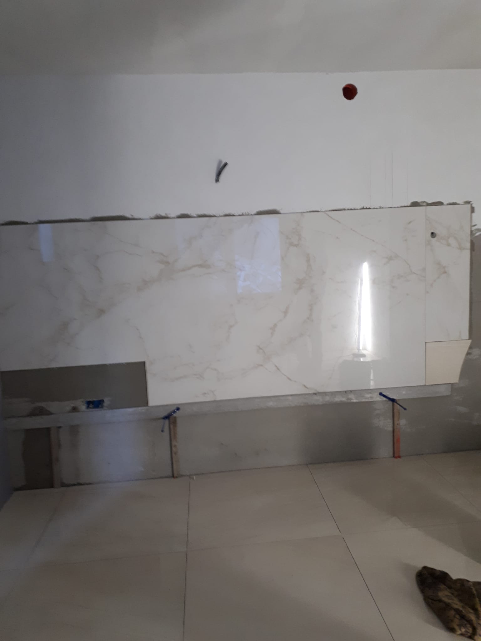 In una cucina viene installata una parete piastrellata bianca.