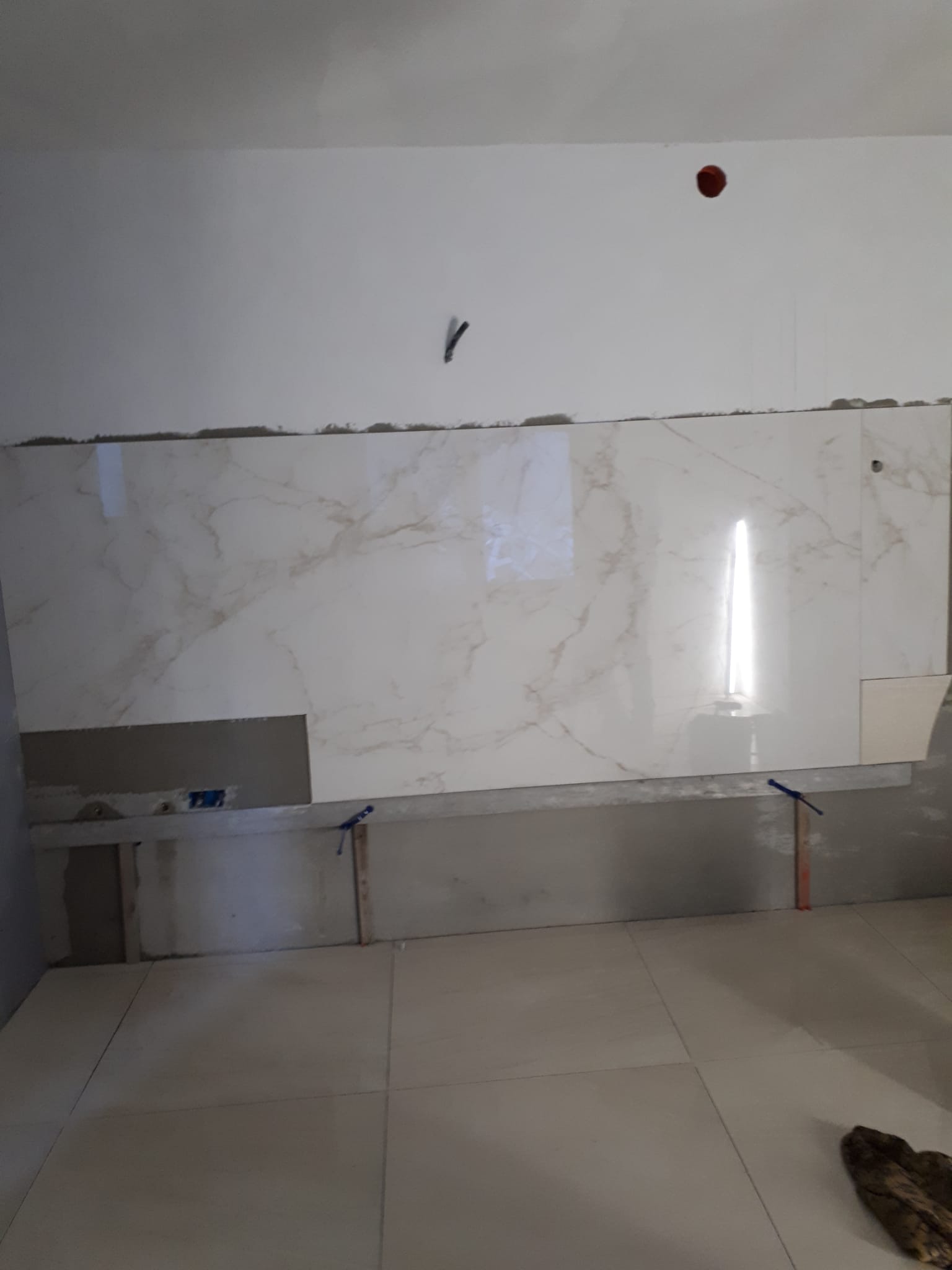 Una stanza con piastrelle bianche sulle pareti e sul pavimento.