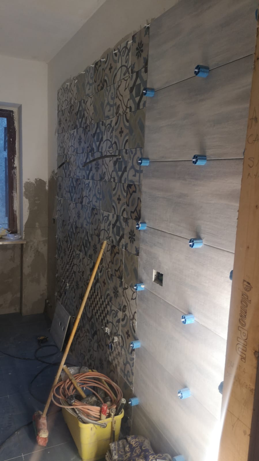 Un bagno in costruzione con piastrelle installate sul muro.