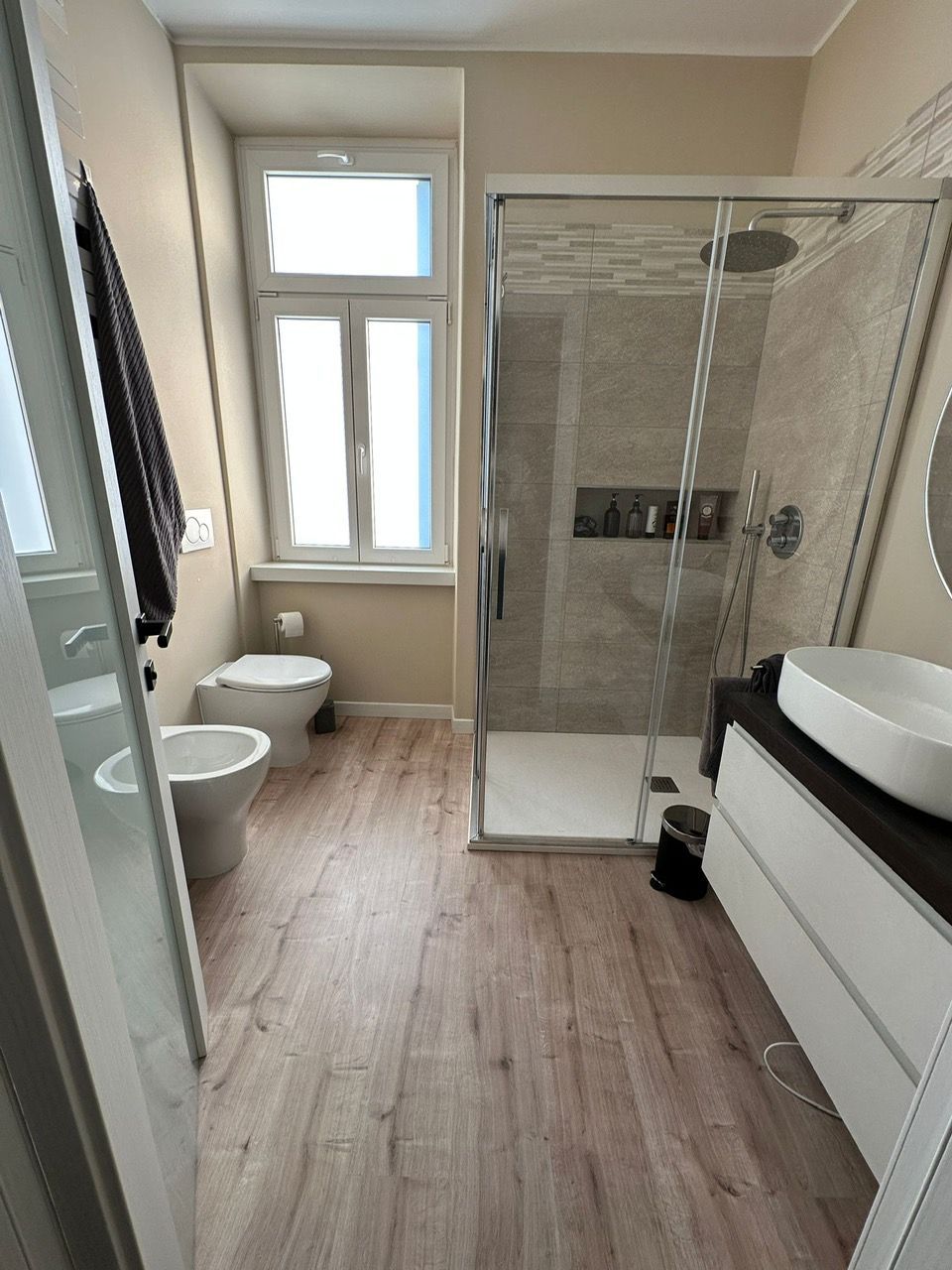 Un bagno con cabina doccia, lavandino, wc e bidet