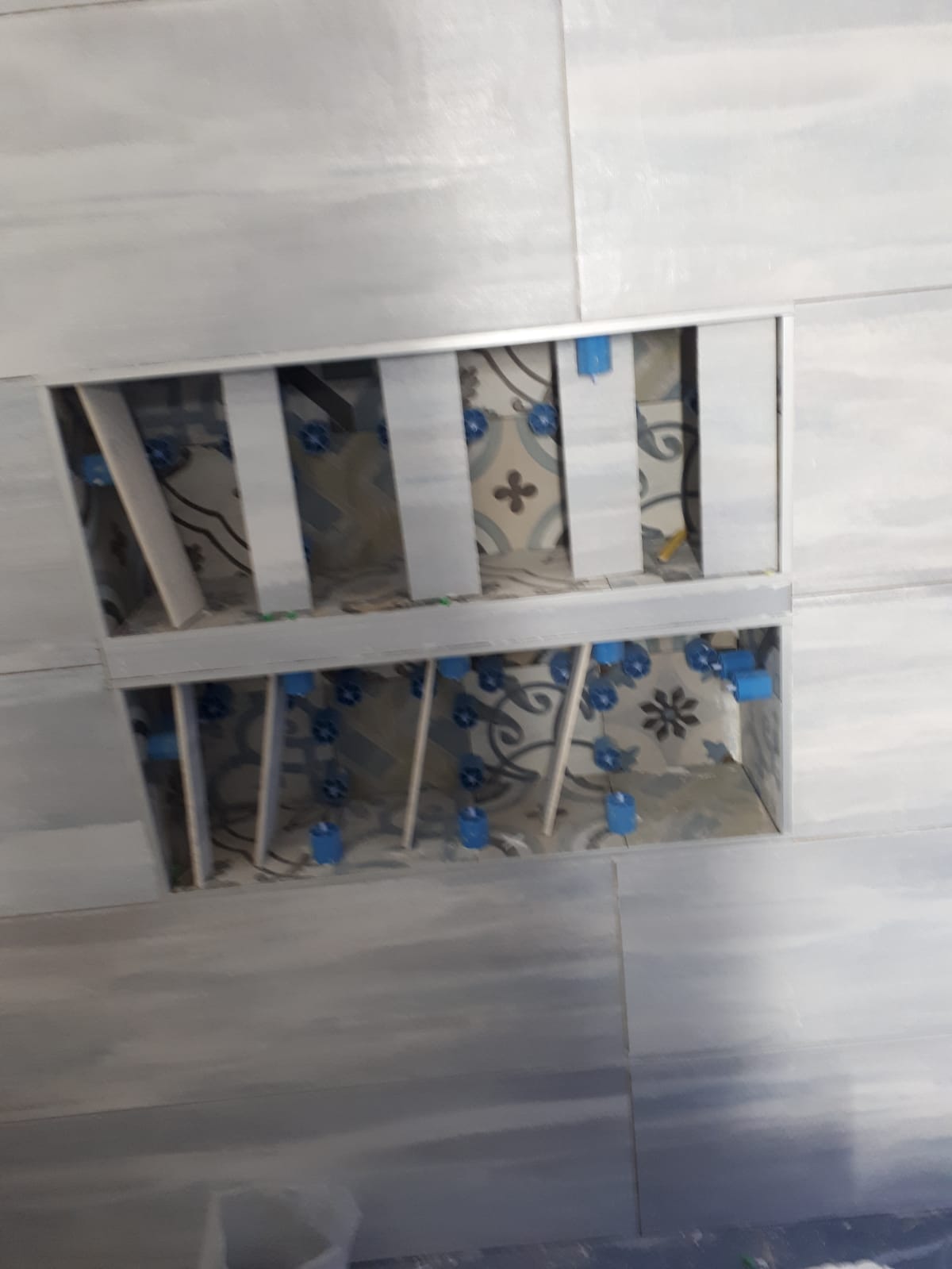 Un soffitto con un buco e delle piastrelle sopra.