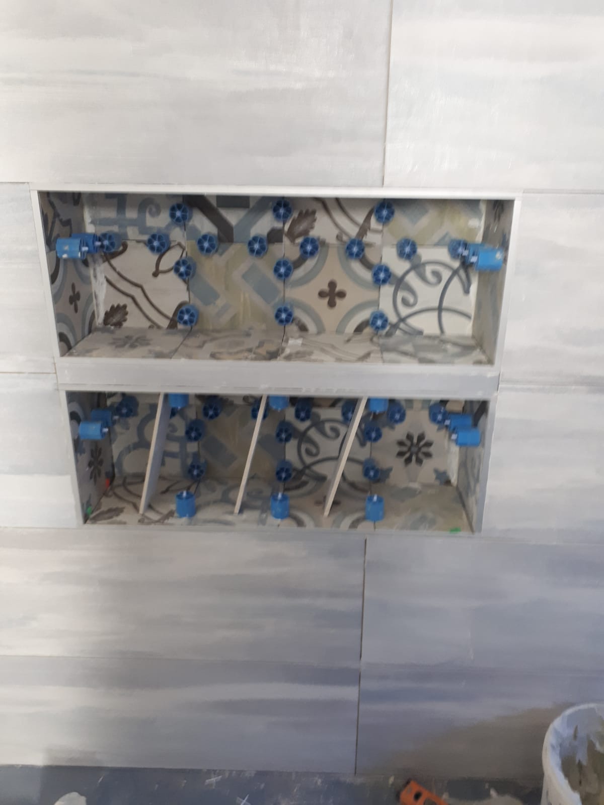 In un bagno viene costruita una mensola con un motivo.