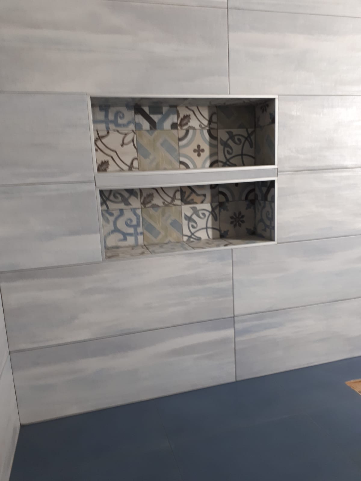 Un bagno con una mensola incassata nel muro.