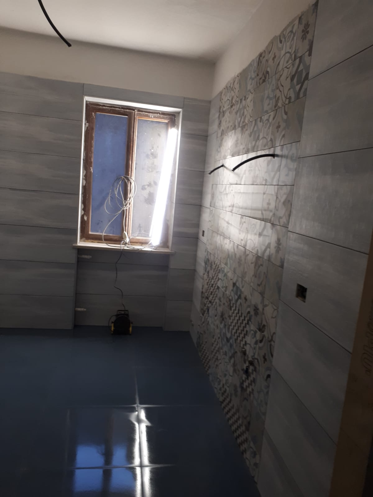 Una stanza con una finestra e un pavimento blu