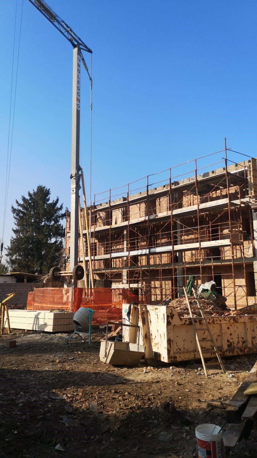 Un grande edificio in costruzione con una gru in primo piano.