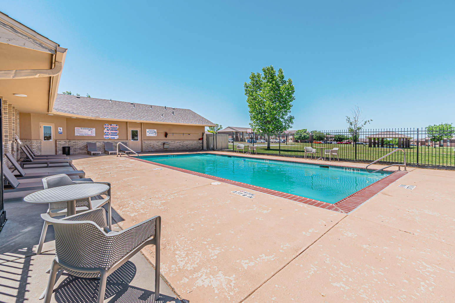 Empty conference room with a large square table, brown chairs, and fluorescent ceiling lights