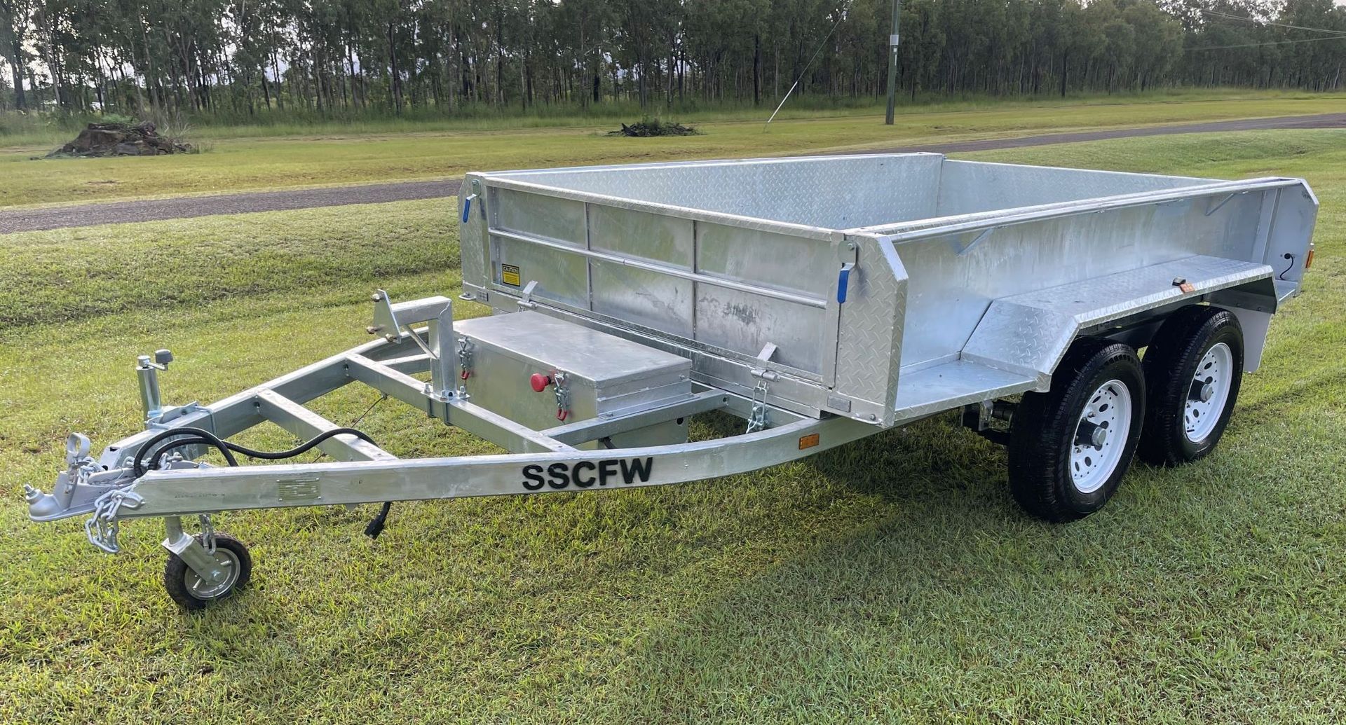 A trailer is parked on a lush green field.