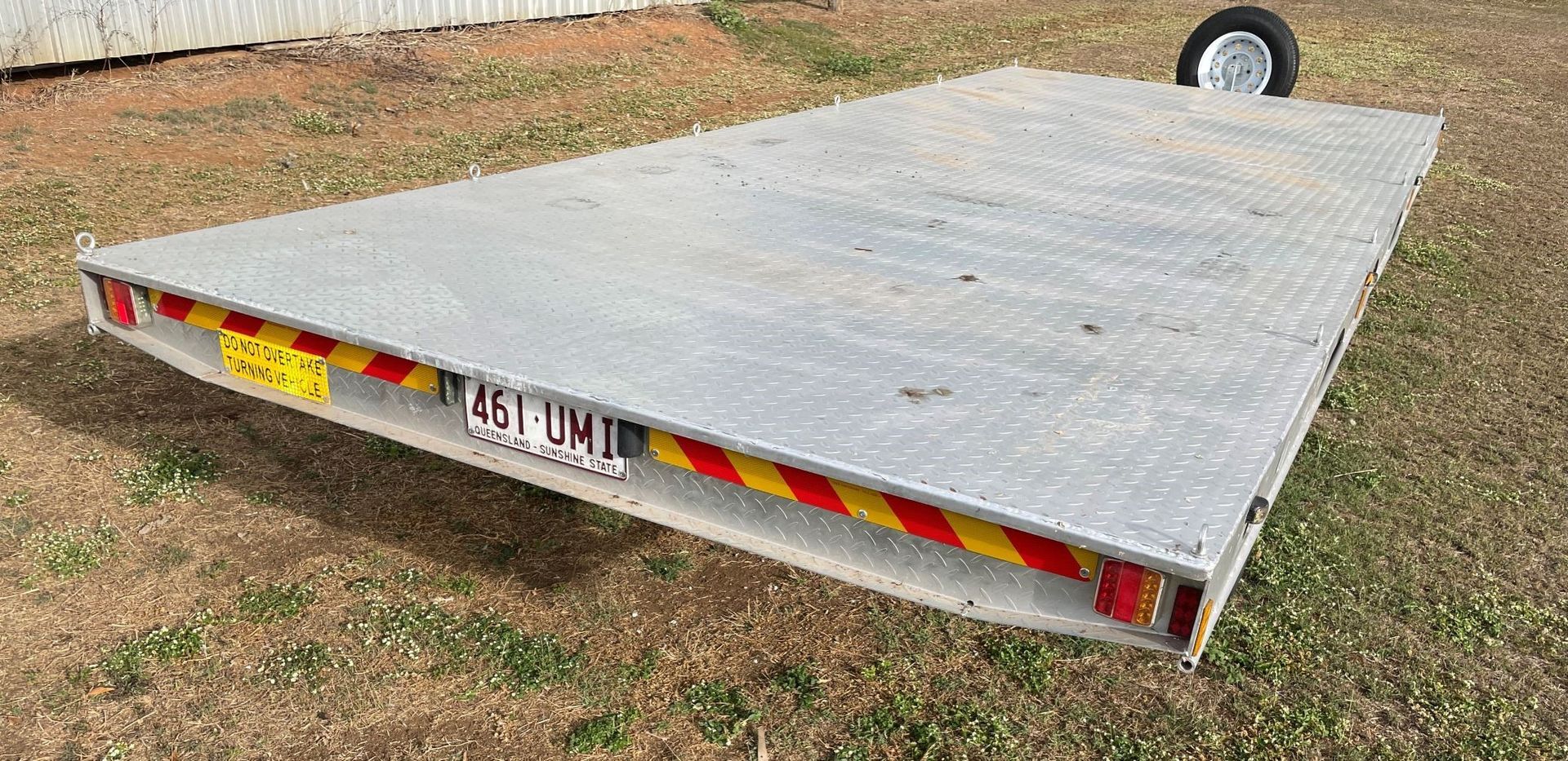 A large metal platform is sitting on top of a grassy field.