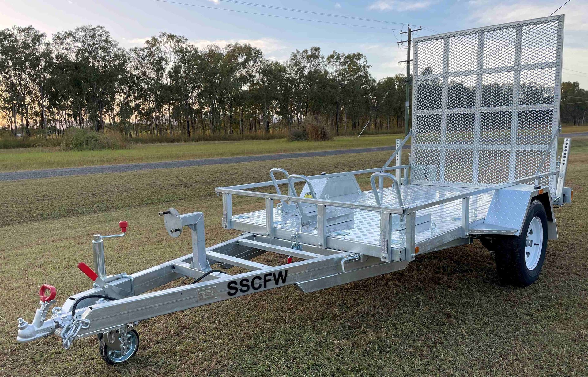 A motorcycle trailer is parked in a grassy field.