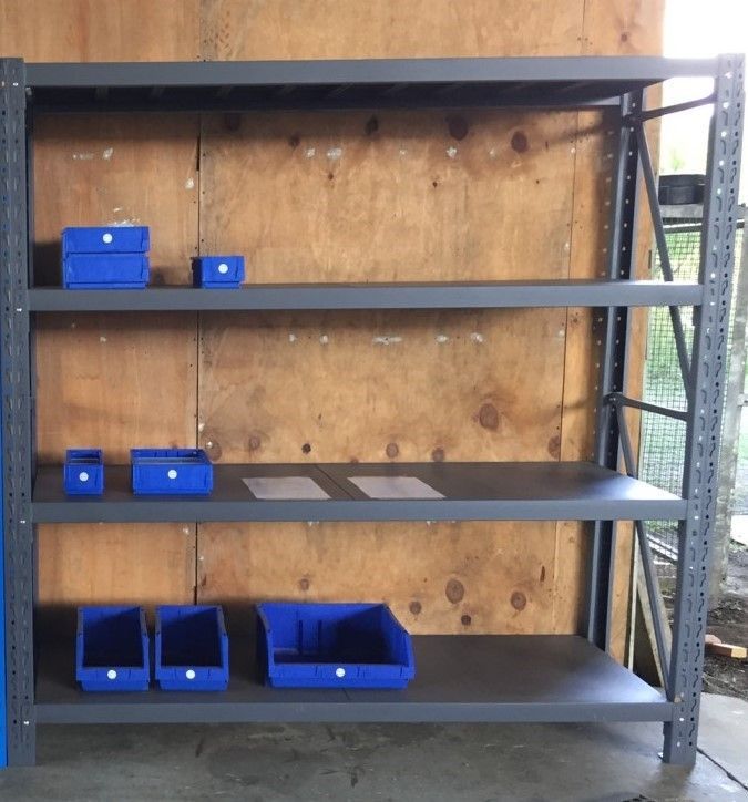 A shelf with blue bins and boxes on it