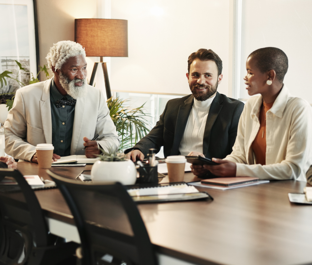 A group of people are sitting at a table having a meeting.