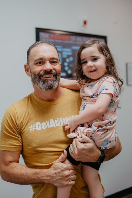 A man is holding a little girl in his arms.