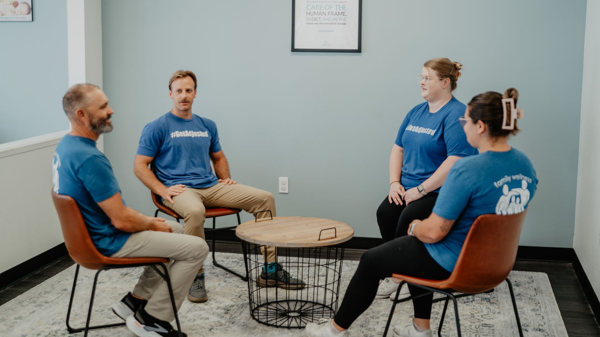 A group of people are sitting around a table in a room.