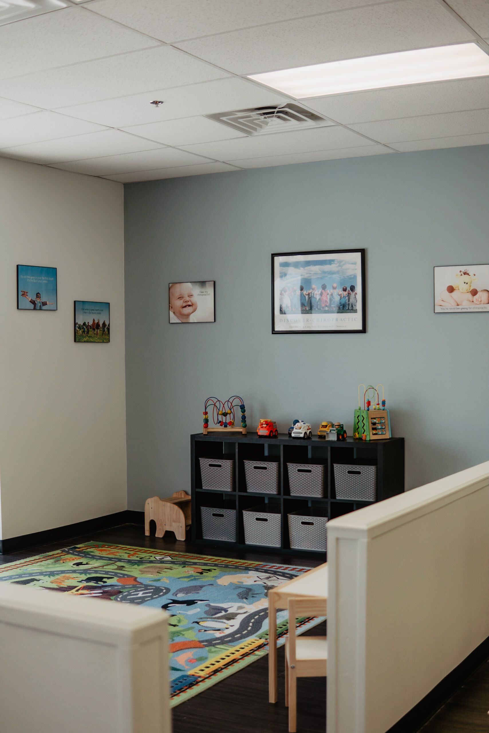 A room with a table and chairs and a rug on the floor.