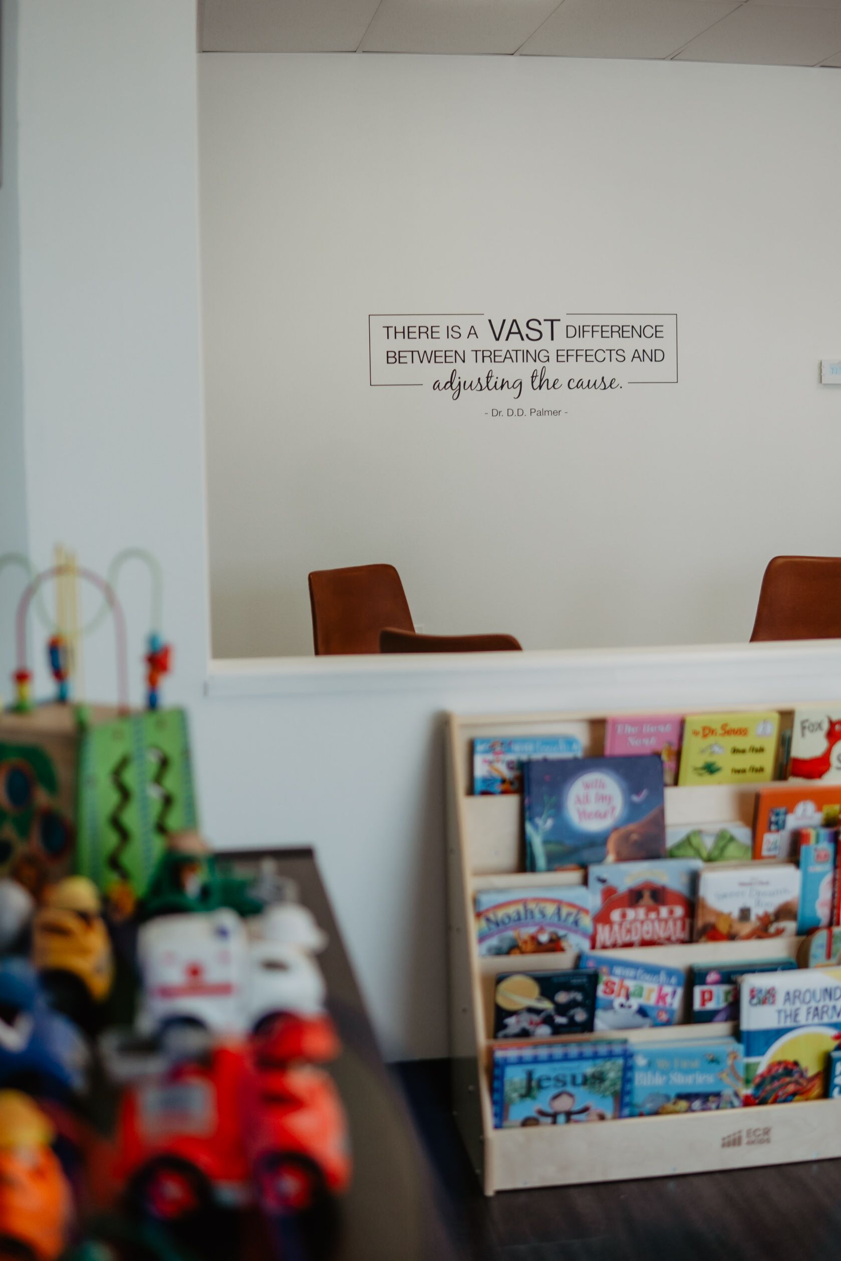A bookshelf filled with books and toys in a room