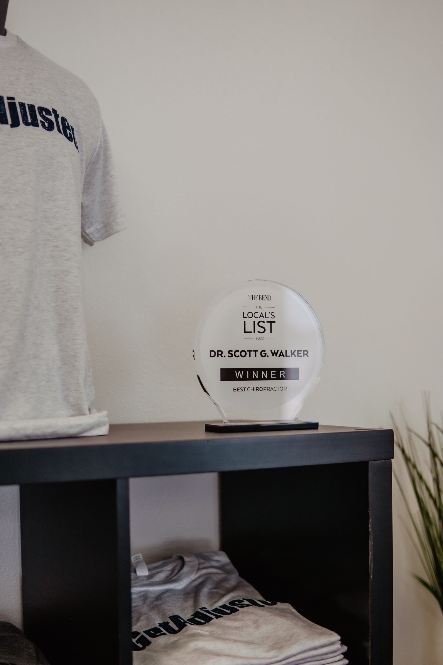 A trophy is sitting on top of a shelf next to a mannequin.