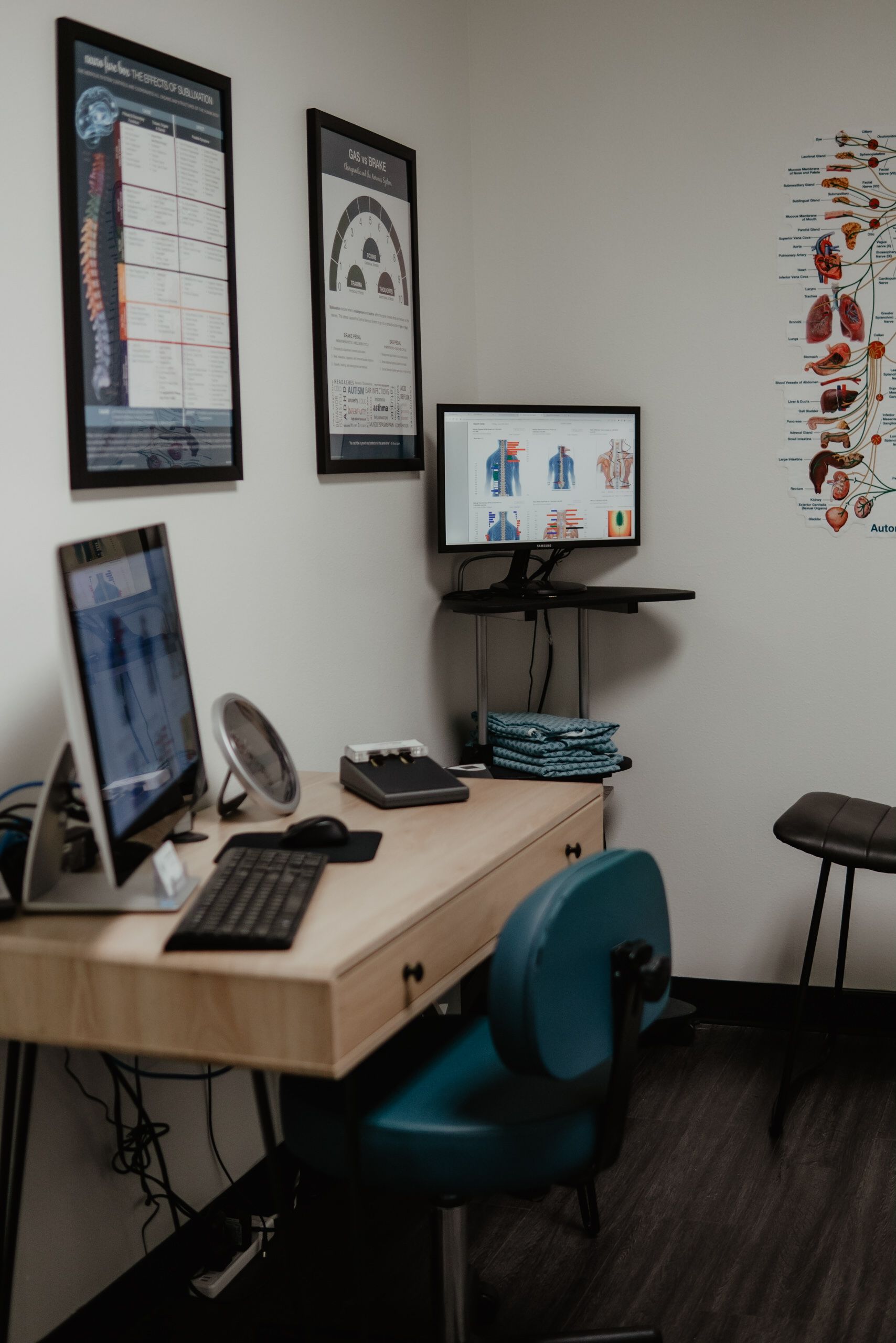 A doctor 's office with a desk , chair and computer.