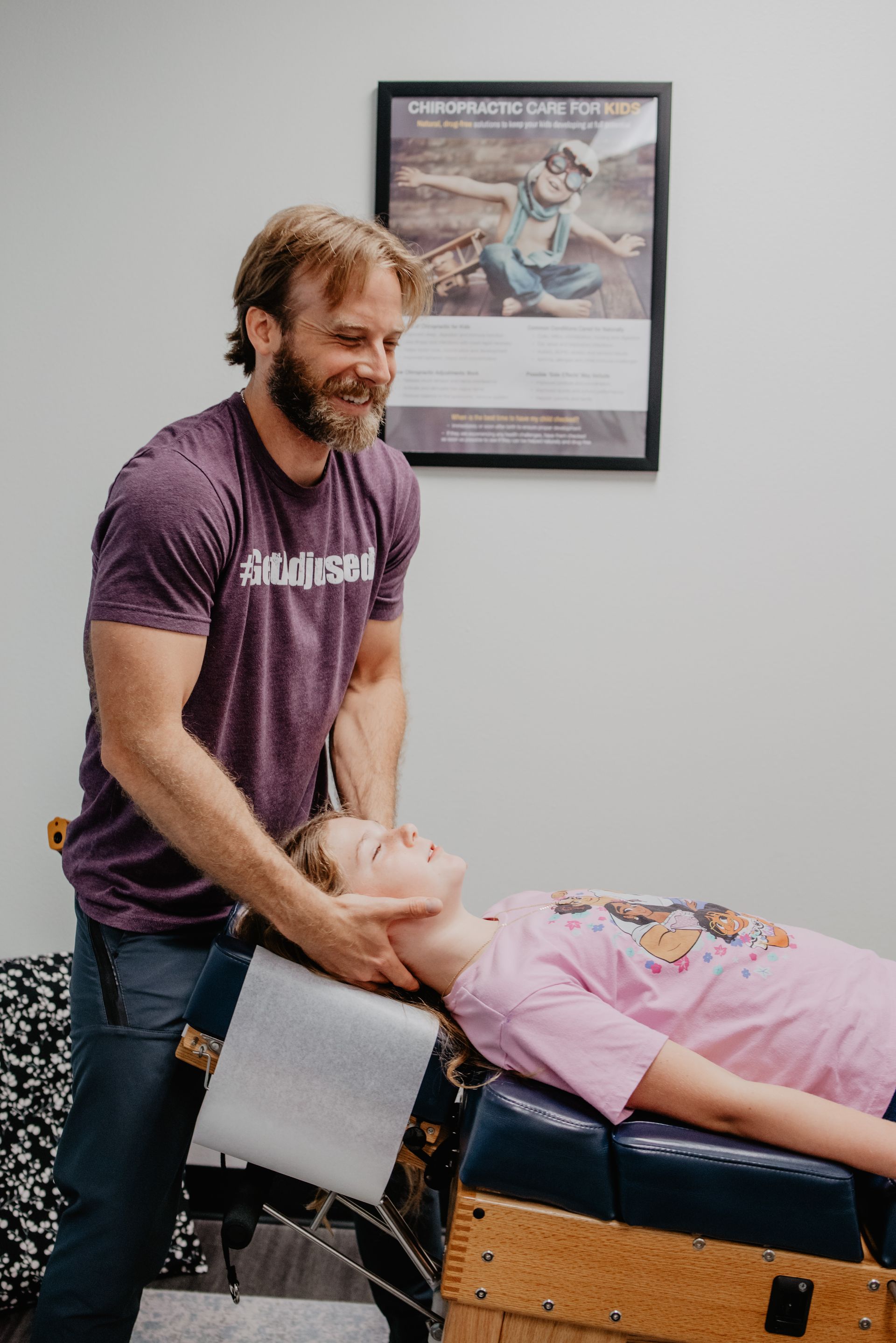 A man in a blue shirt is holding a baby in his arms.