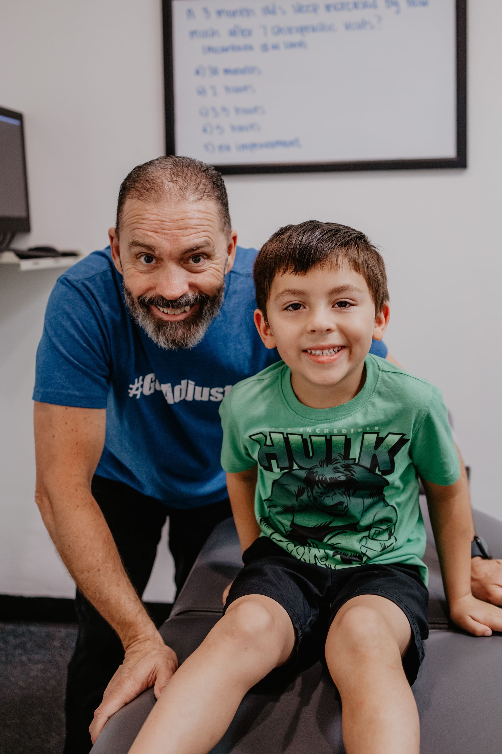 A girl and a boy are sitting next to each other on a bench.