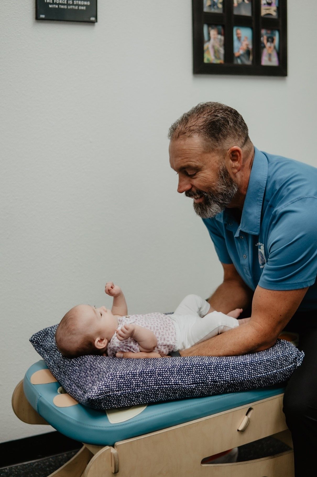 A man is playing with a baby on a table.