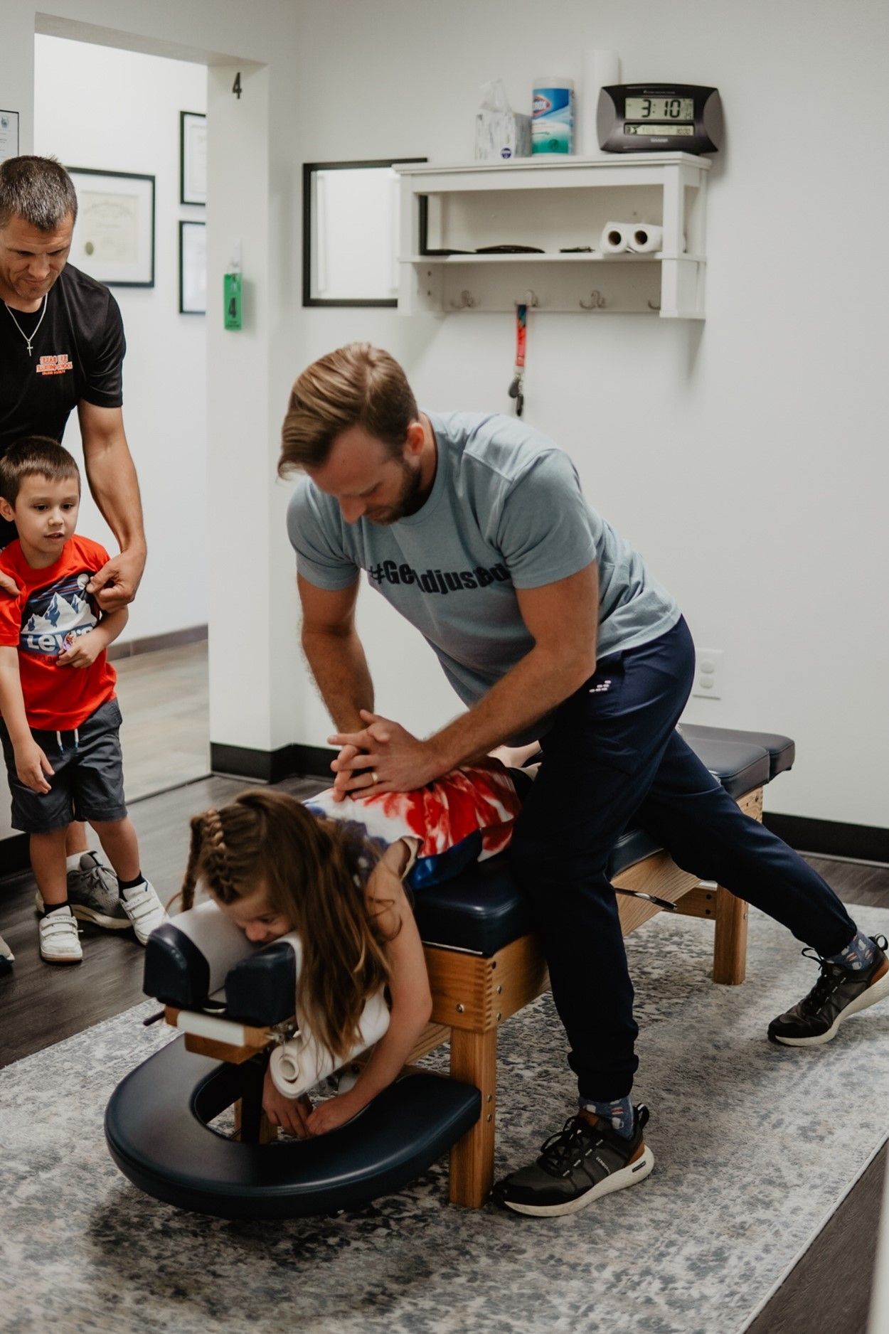 A man is giving a child a massage on a table.