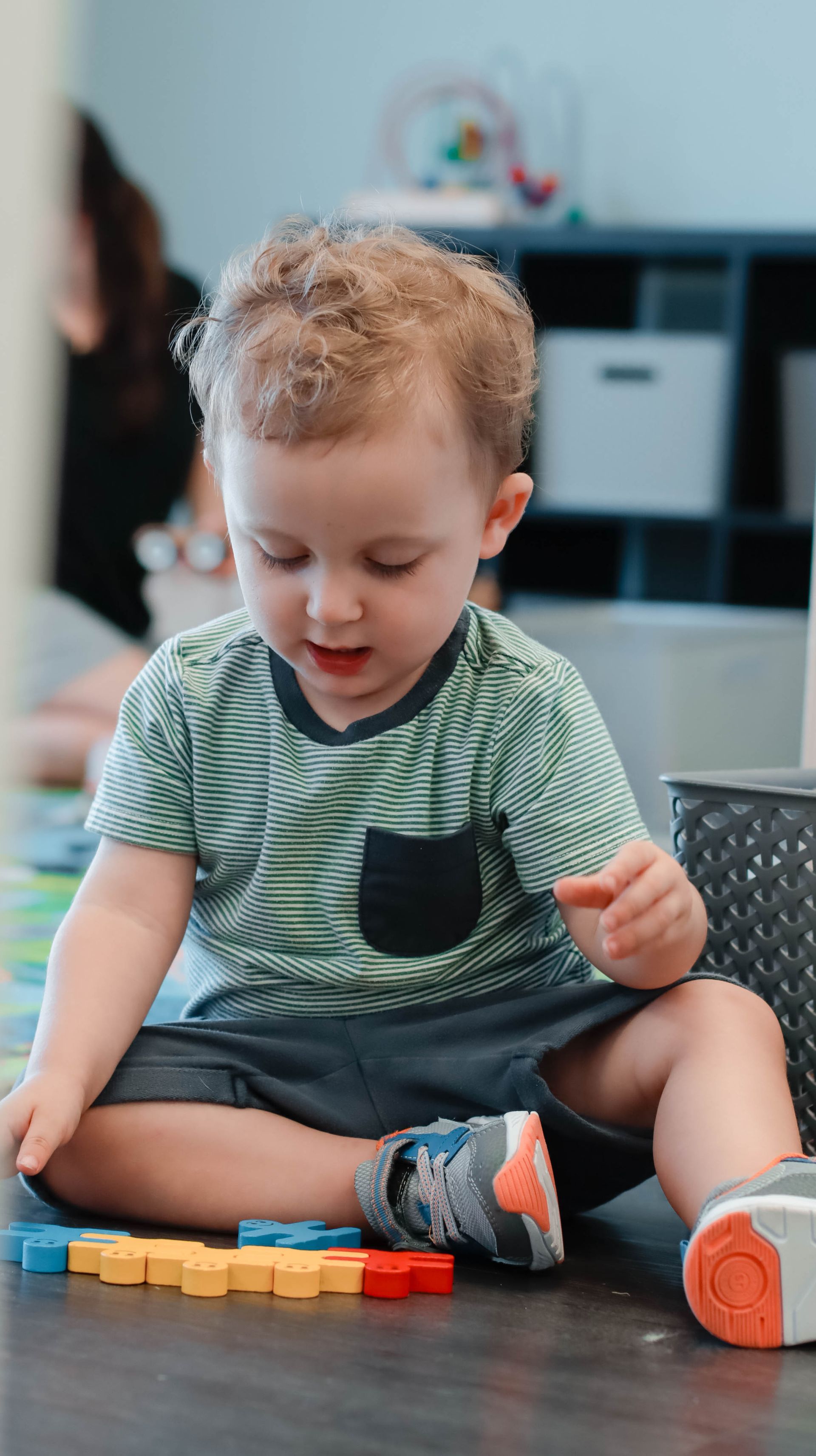 A young boy is sitting on the floor playing with blocks.