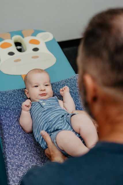 A man is holding a baby on a changing table.
