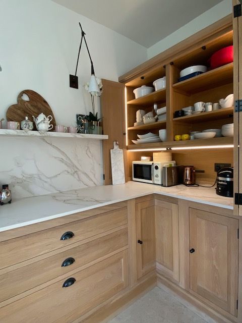 Oak kitchen with wide pan drawers 
 bifolds floating shelf and wall lights, natural textures