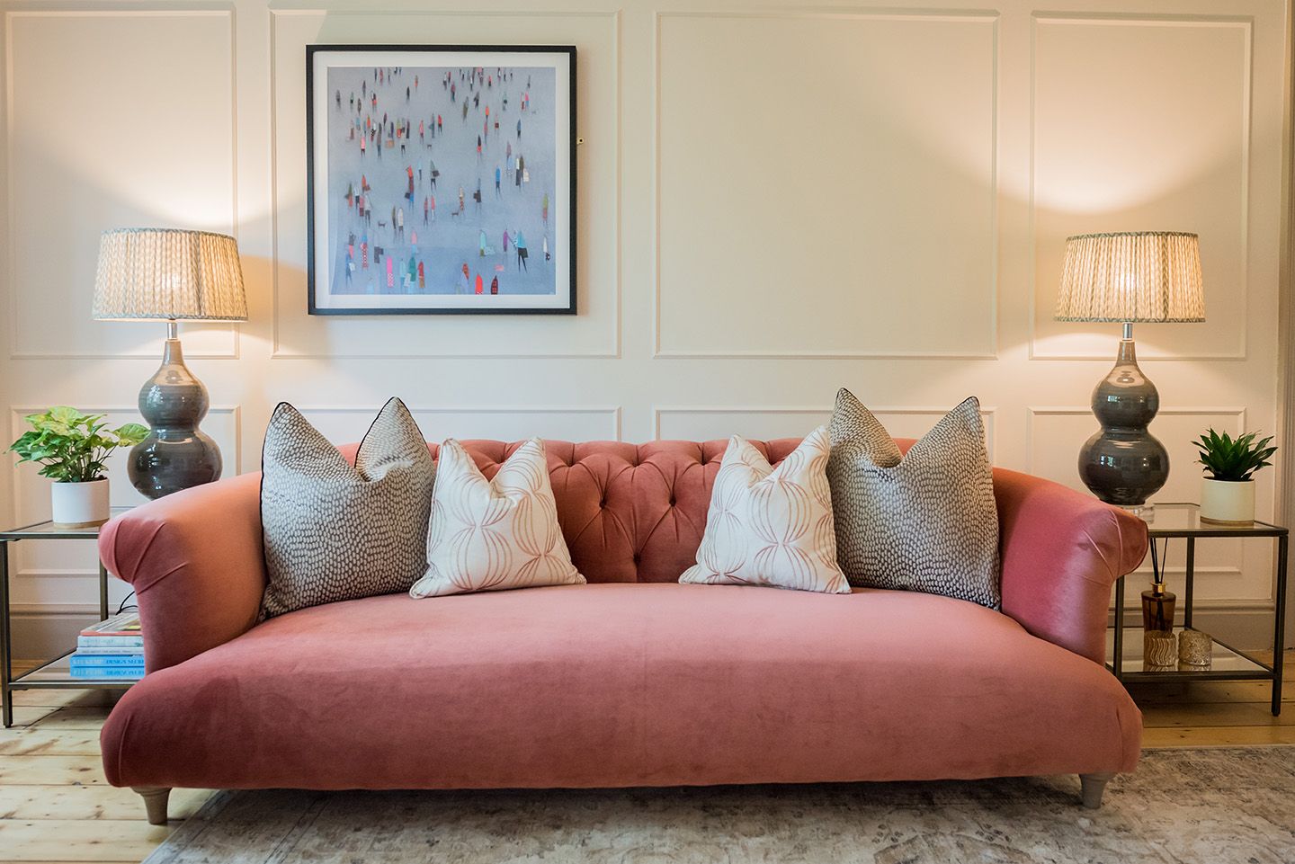 Pink Velvet sofa with taupe cushions, glass side tables and grey table lamps