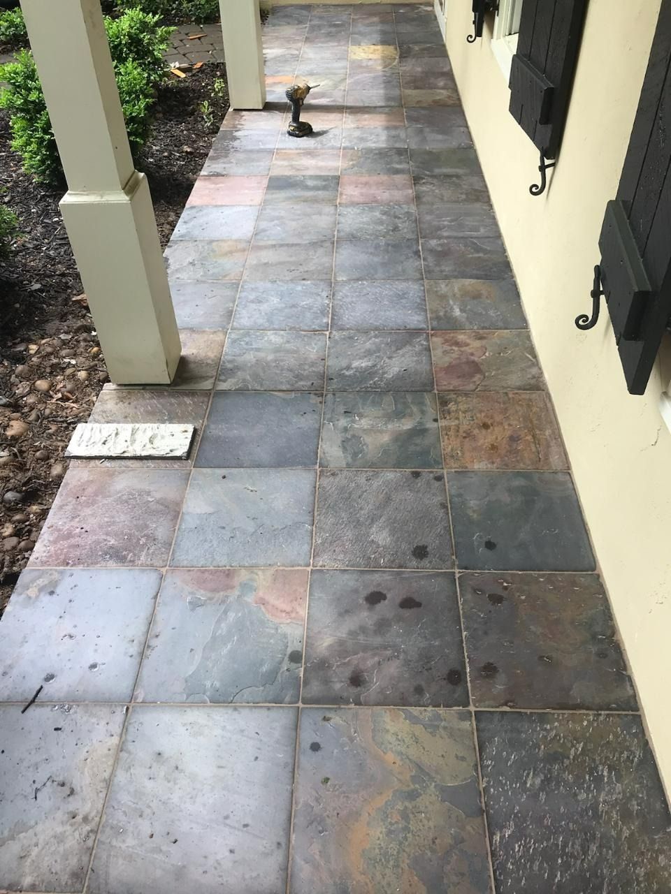 Slate tile walkway along a house. Dark gray, green, and brown tiles.