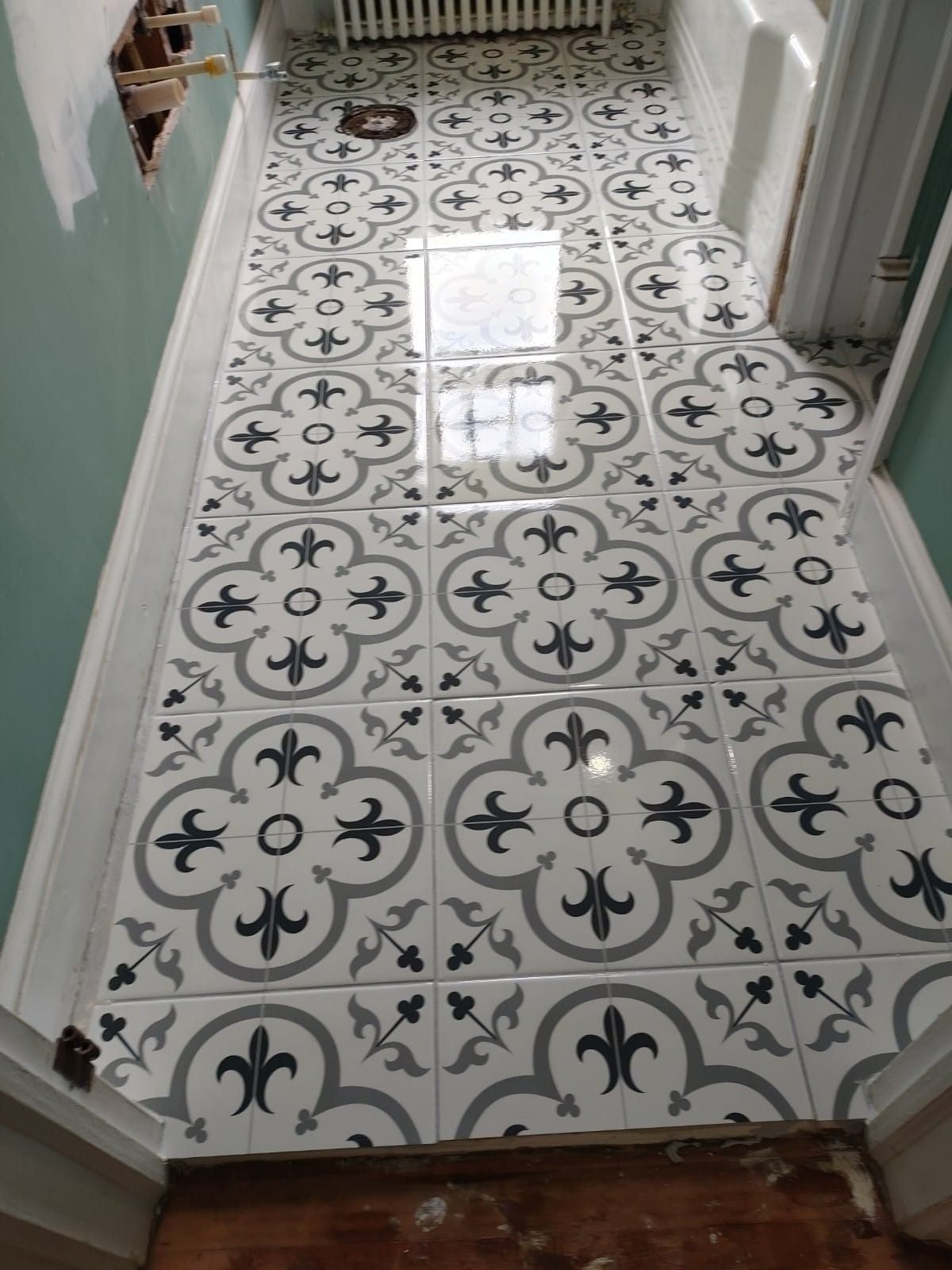 Bathroom floor with patterned gray and white tiles.