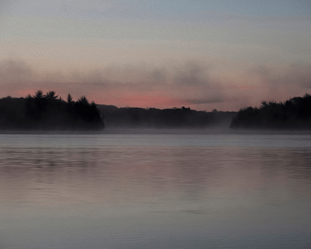 Misty lake at dawn with dark tree-lined shores and a pink sky reflection