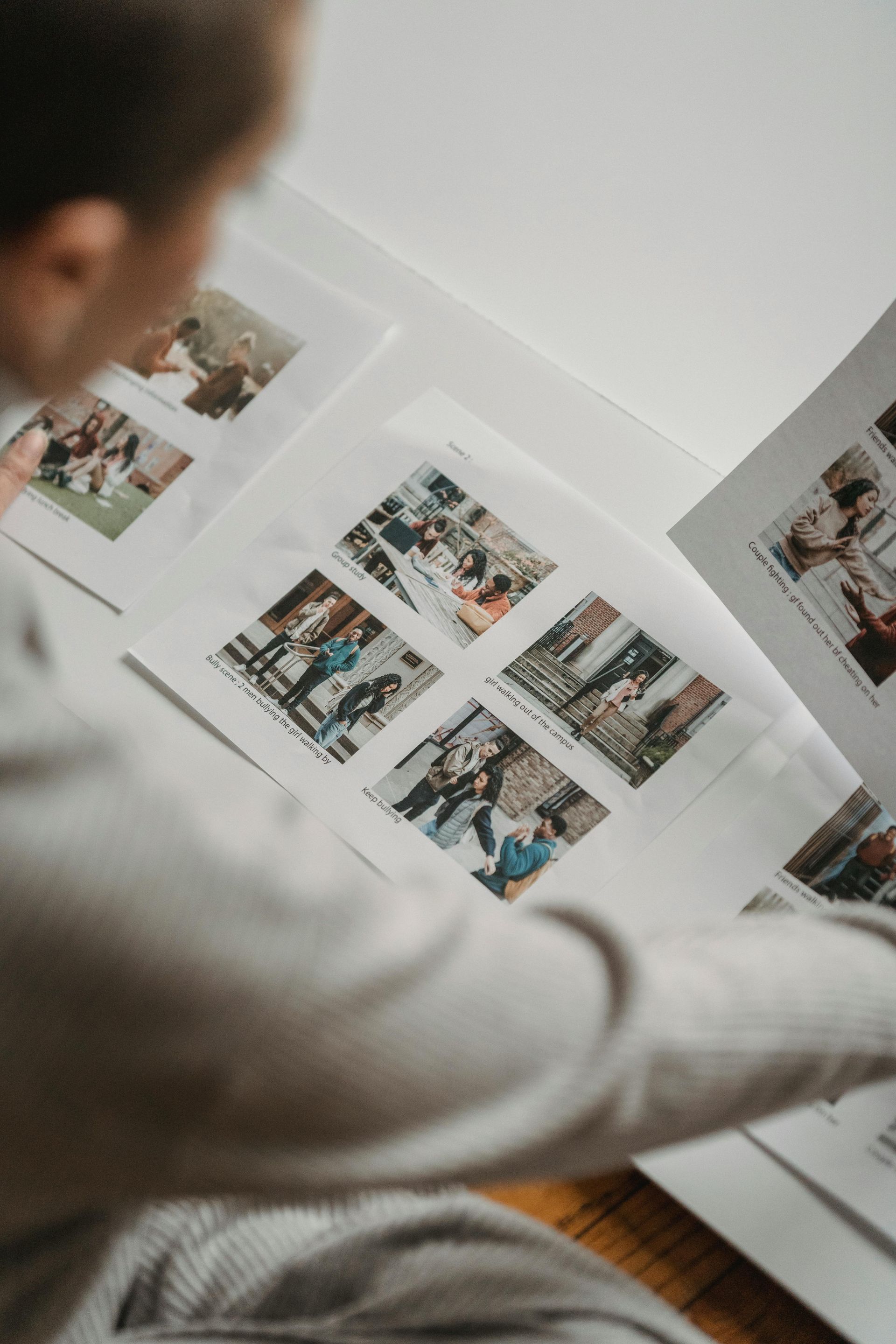 Person reviewing printed photo layouts on a desk