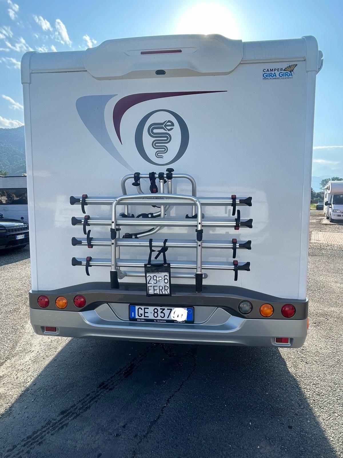 Parte posteriore di un camper bianco con portabici. Targa